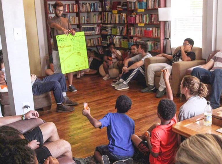 Children listening to a group leader at the Maple House